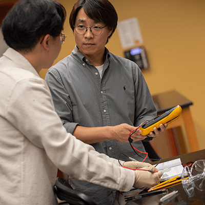 Two students discussing some technology together in a lab.