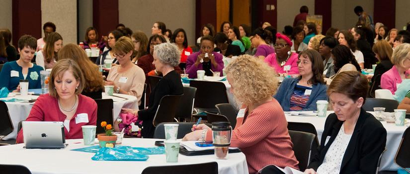 Women at tables attending a conference