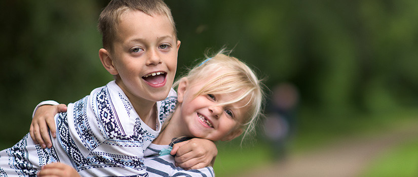 A little boy with Autism and girl (brother and sister) sitting playing together