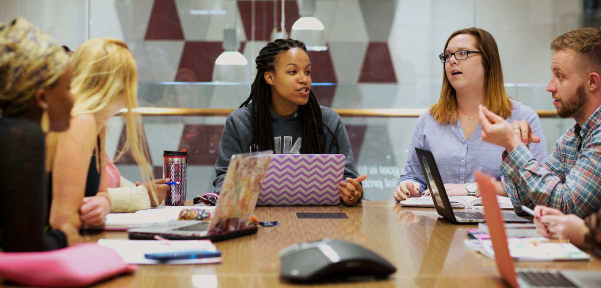 Students discussing something around a table