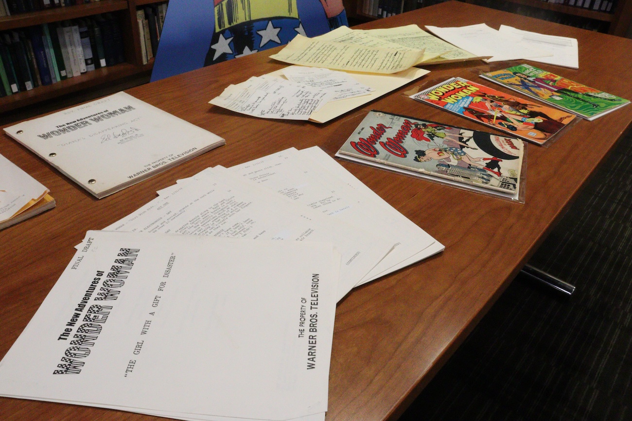 Wonder Woman scripts and comics on table.