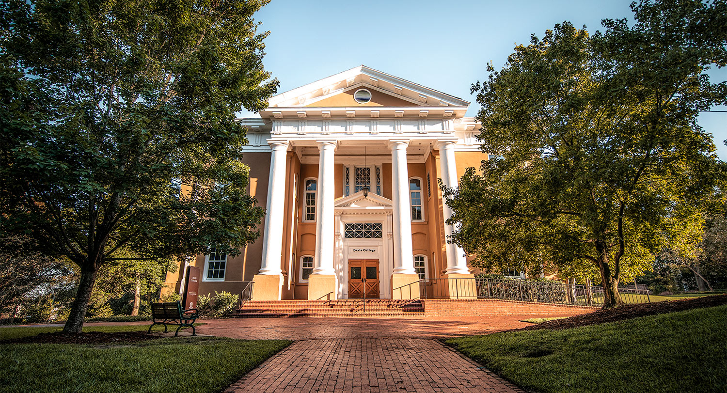 Davis College stands tall with large white columns surrounded by trees.