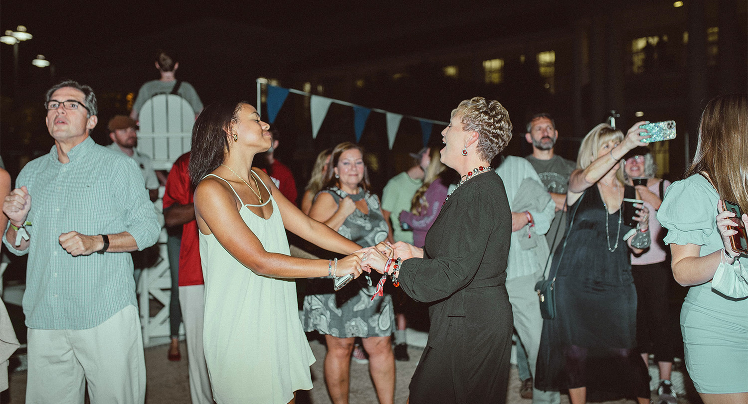 Family members dance outdoors at a Family Weekend event.