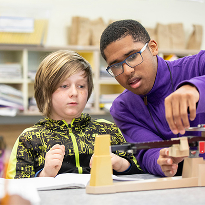 Student teacher working with a child with a scale.