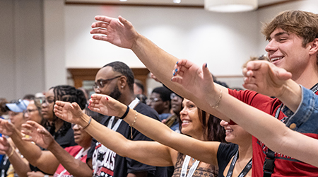 A group practices the Alma Mater at Orientation.