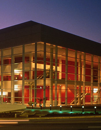 The Koger Center for the Arts light up against a sunset sky.