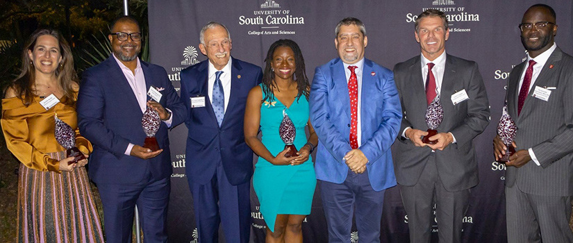 people smiling as they receive awards.