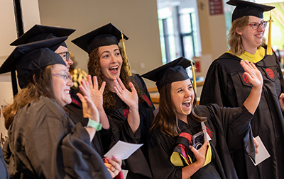 Students laughing with caps and gowns on