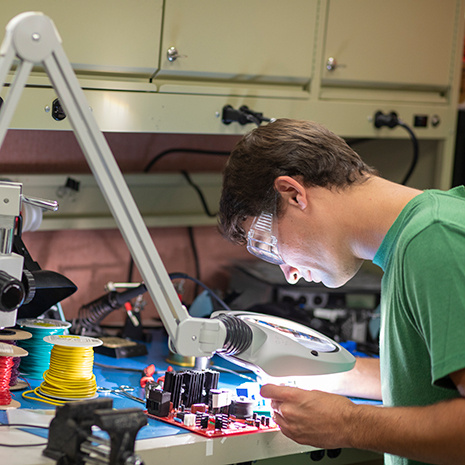 male student works with electrical equipment