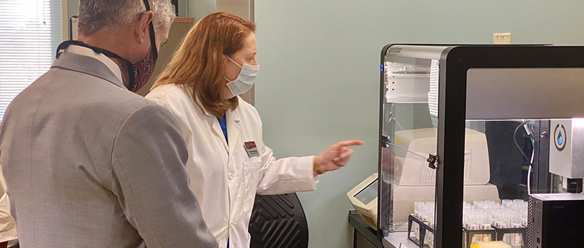 Carolyn Banister shows testing robot to President Caslen