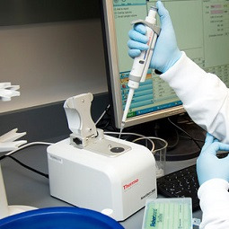 Woman in lab coat working with medical equipment