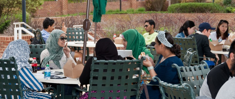 Young people sitting at a patio table having a conversation