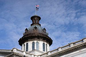 SC statehouse dome with U.S., SC, and USC flags flying