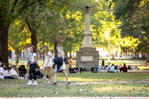 students on the horseshoe greenspace with an obelisk in the background