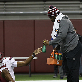 Ronald Parker assist football players during warm-up