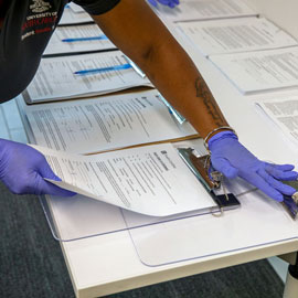 health worker handles forms related to COVID-19 testing