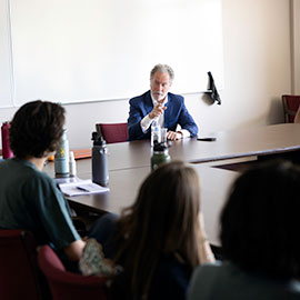 David Beasley speaks to students sitting around a rectangular table