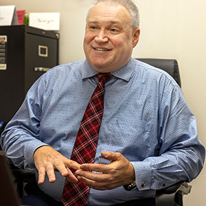 Alexander Gasparian sits at his desk and looks off camera