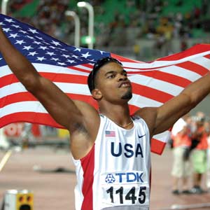 Hurdler Terrence Trammell holds the U.S. flag