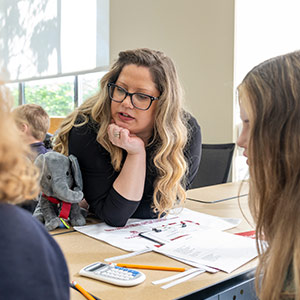 Teacher working with students at a table in classroom